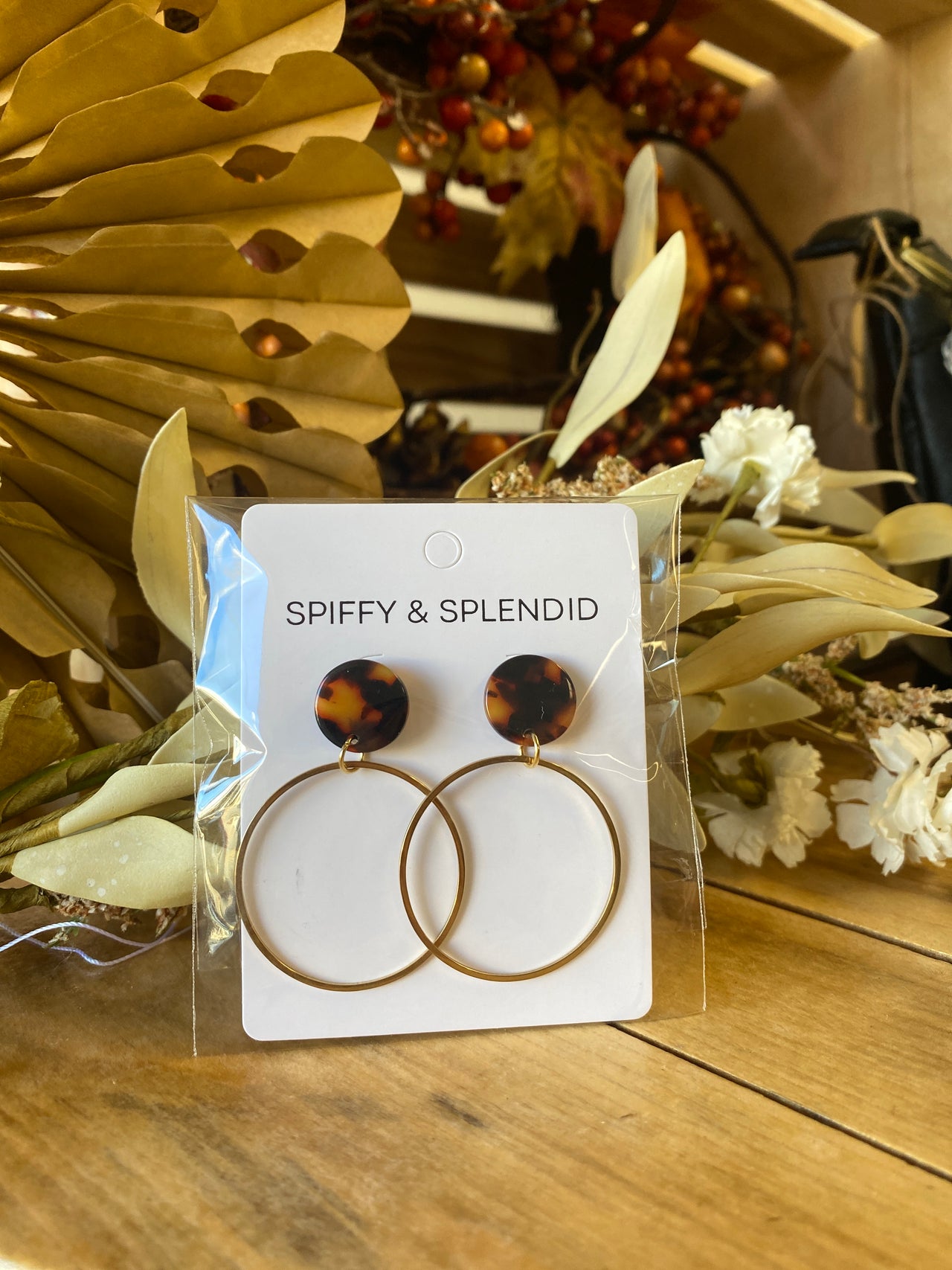 Pair of round earrings with tortoiseshell and gold design on a 'Spiffy & Splendid' card, surrounded by decorative elements.