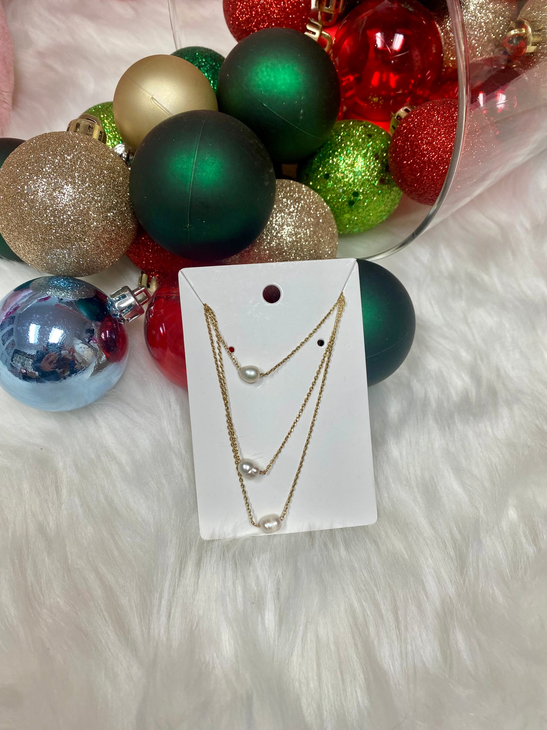 Necklace set on a card with Christmas ornaments in the background